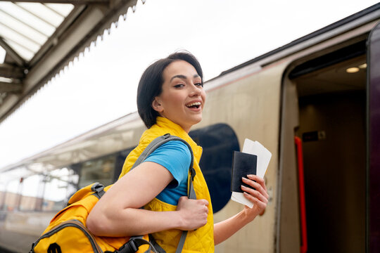 Young traveler boarding a train with excitement at the station