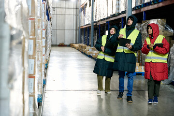 Cold chain workers checking inventory in large warehouse