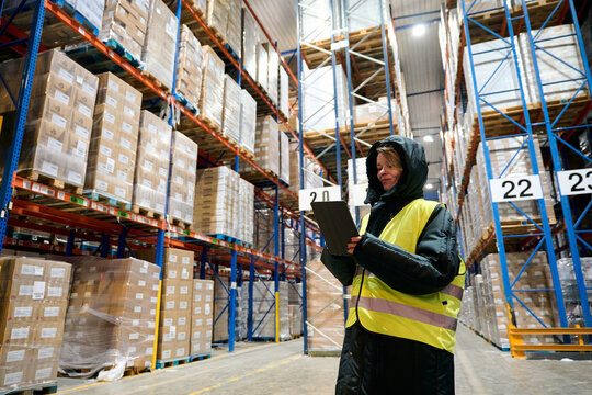 Worker checking inventory in cold chain warehouse