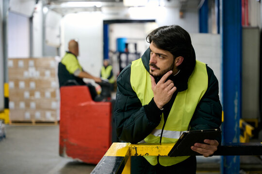 Logistics manager thinking about inventory control in cold chain warehouse - Powered by Adobe