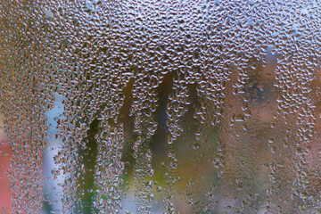 background of wet glass. water droplets on glass surface create beautiful abstract pattern. background for design and creatives. Water drops on glass surface form intricate abstract patterns.
