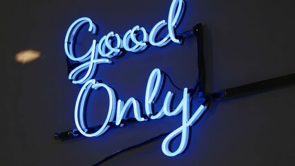 Blue neon good only sign glowing in dark interior creating positive uplifting atmosphere with modern handwritten style and vibrant illuminated aesthetic - Powered by Adobe