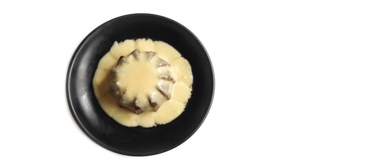 Chocolate Pudding with Creamy Vanilla Sauce  Custard on Black Plate Isolated on White Background. Food Stylish Photography