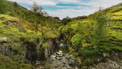 Hiking through the highlands during autumn in Scotland along the River Coe at Glencoe in Ballachulish, UK