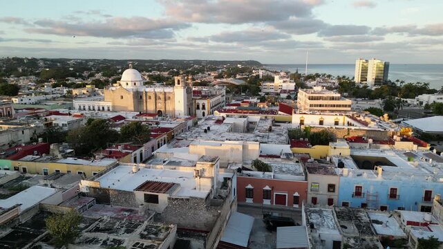 flying above scenic colorful colonial street in campeche yucatan peninsula (spanish architecture streetscape scene) gulf mexico sunrise glow cornice building beautiful downtown city center aerial view