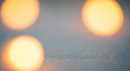 Soft focus abstract image featuring warm golden bokeh lights floating above a sparkling, glittering surface, ideal for holiday and festive designs and backgrounds