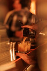 Shaken cocktail being poured into rocks glass
Bartender pouring mixed cocktail over ice
Classic shaken cocktail served in elegant bar