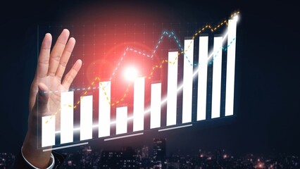 A hand reaching toward a rising growth graph illuminated by sunlight against a city skyline. This...