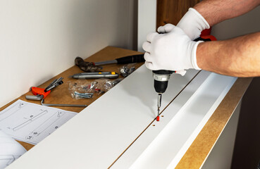 Assembling cabinet furniture with an electric screwdriver