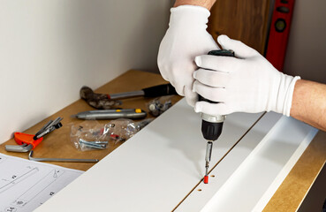 Assembling cabinet furniture with an electric screwdriver