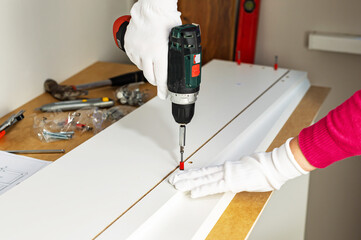 Assembling cabinet furniture with an electric screwdriver