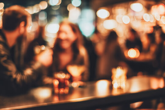 Defocused friends laughing and clinking glasses at cozy bar, warm lighting, festive atmosphere, blurred background, social gathering, night out, cheerful mood - Powered by Adobe