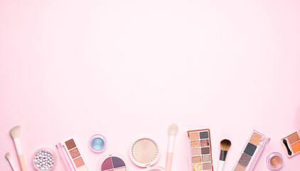 Set of decorative cosmetic products and make up brushes on light pink background with copy space for tour design top view. Cosmetic sale and promo banner.