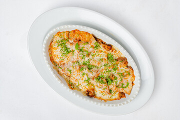 A warm casserole dish, filled with savory goodness and topped with herbs, sits invitingly