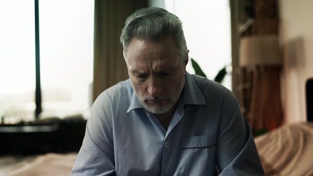 Unhappy man in his 50s taking medication with water, chronic disease treatment