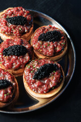 Mini beef tartare tartlets topped with black caviar
Gourmet tartare appetizer with premium black caviar
Luxury beef tartare canape with caviar topping