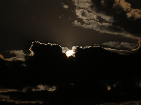Dramatic storm clouds with bright silver lining backlit by sun