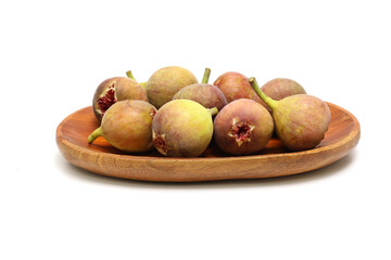 白背景の木製の皿にのせたイチジク