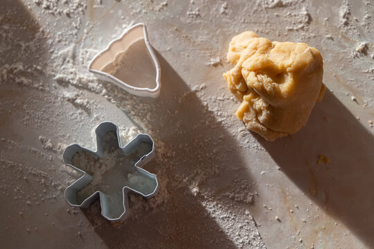 A family baking scene with children preparing German-style cut-out cookies. Little hands working with flour, dough, and festive cookie cutters.