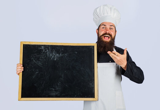 Chef man. Male cook in chef hat with blank chalkboard for business lunch menu. Happy bearded chef, baker or cook with blackboard for advertising restaurant menu. Empty menu sign board with copy space.
