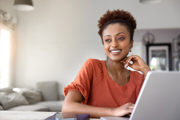 Positive Black freelancer woman enjoying remote work at laptop
