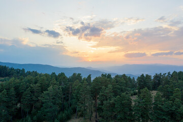 Beautiful landscape, the rising sun illuminated the slopes of the Rhodope Mountains covered in coniferous forest. Sunrise in the mountains. Travel and Vacation Concept in Bulgaria