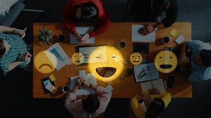 A diverse team collaborates around a table, sharing ideas and expressing emotions visually,...