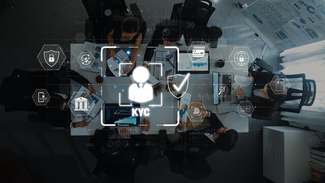 A top-down view of a team engaged in the Know Your Customer process, featuring digital tools for data analysis and compliance in a modern work setting. Raster - Powered by Adobe