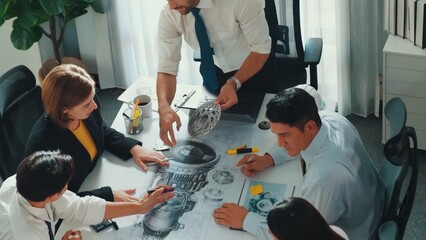 Group of diverse team planning strategy while sitting at table with project plan. Top aerial view of smart business people working together to brainstorm and design house construction. Alimentation.