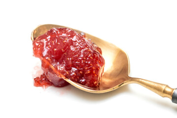 chunky red raspberry jam resting on a vintage gold-toned spoon. The preserves show seeds and texture, isolated on a clean white background. Perfect for food, breakfast, and sweet concepts.