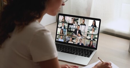 Businesswoman engages in videocall with group displayed on laptop screen - Powered by Adobe