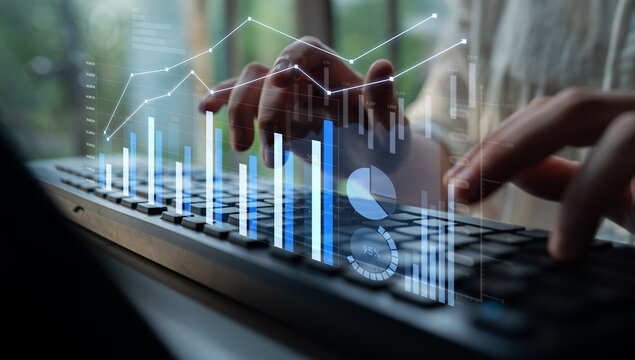 Close-up of hands typing on a sleek keyboard, overlaid with digital graphs and charts, illustrating financial analysis and technology insights in a professional setting. Scalp