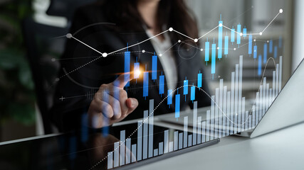 A businesswoman engages with digital data displays, analyzing charts and graphs that symbolize financial growth and market trends in a modern office. Scalp