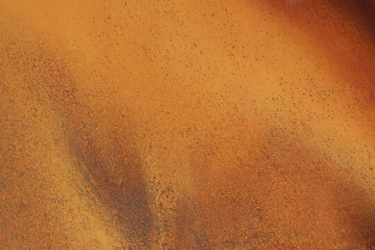 Rusty metal background in brown, red and orange colors. Rusty m&eacute;tal with particles and texture. Grainy rust and construction industry. Canvas and pattern in metallic texture.