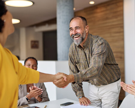 Group of  businesspeople having a meeting shaking hands handshake introducing each other and applauding during meeting in the office. Teamwork and success concept, portrait of a middle aged mature bus