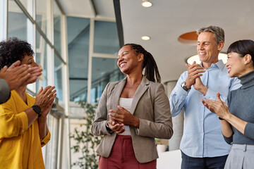 Portrait of a businesswoman celebrating during a meeting in office, group of businesspeople celebrating success, applauding and smiling, teamwork concept