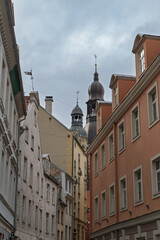 Obraz premium A view of historic buildings and church spires under a cloudy sky in Riga, Latvia