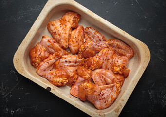 Raw marinated chicken wings spices red sauce paprika baking tray cooking top view