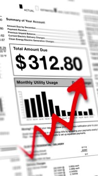 A vertical  close-up of a utility bill shows a high amount due, with a red upward arrow indicating rising energy costs and consumption on a usage graph.