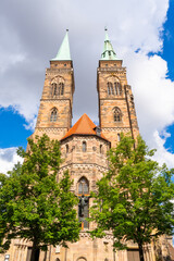 Fototapeta premium Saint Sebald Church on Sunny Day. Green Trees. Nuremberg, Franconia, Germany