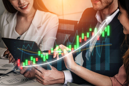 A business team collaborates in a modern office, analyzing financial data on a tablet. The background features vibrant charts and graphs indicating growth trends. Impute