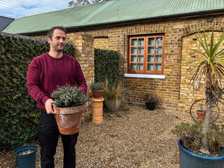 Man Holding Flower Pot in Garden