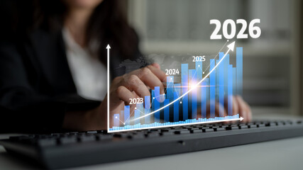 A business professional interacts with a computer while analyzing projected financial growth from...