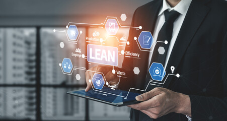 Business professional analyzes lean management concepts on a tablet, focusing on efficiency, productivity, and waste reduction in a modern office setting. Tessel