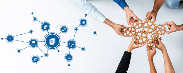 This image depicts a collaborative management theme, showcasing diverse hands holding wooden gears above a digital tools icon, symbolizing teamwork and strategic planning. Amity