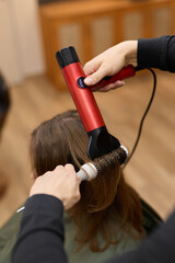 Fototapeta premium styling action captured, vibrant portrayal of stylist shaping hair amidst lively salon environment