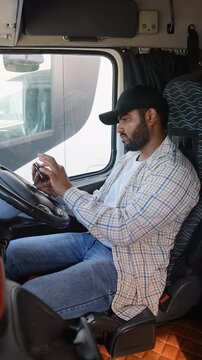 Indian truck driver using a smartphone inside cabin right hand drive car