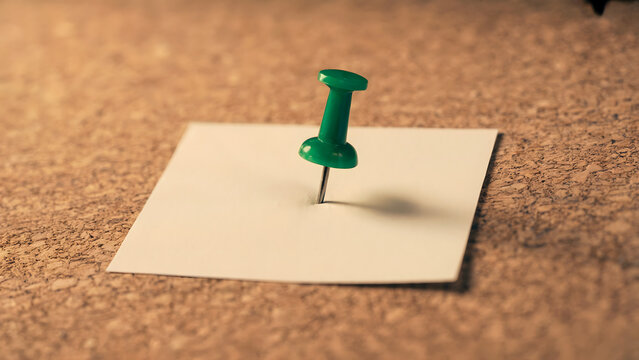 Blank white paper note pinned on cork board, green push pin holding empty memo mockup, blurred bulletin texture background, for reminder, list, notice, office, school.