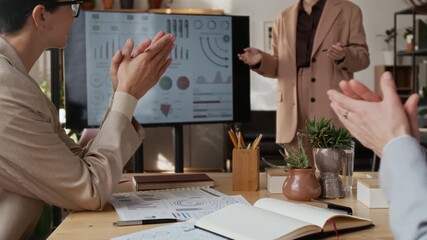Low angle handheld zoom out shot of unrecognizable women in formal outfits applauding after listening to business presentation during meeting in modern office - Powered by Adobe
