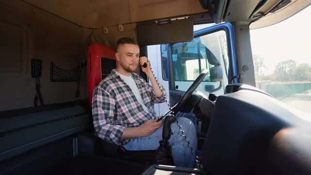 Professional truck driver talking on cb radio inside cabin